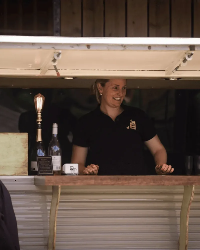 Staff serving drinks from the bar in The Barn at Everards Farm