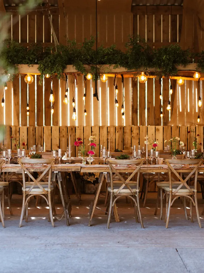 Rustic banquet tables dressed for a wedding in the barn